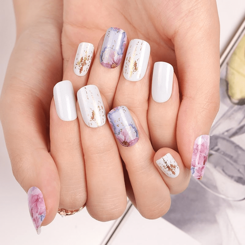 Floral nail wraps manicure on hands with pink purple watercolour blossom design