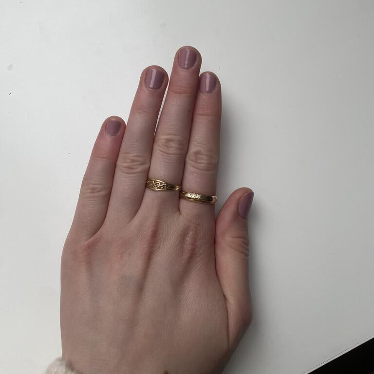 Mauve-pink glossy nail wraps on short round nails, shown on hand with gold rings.