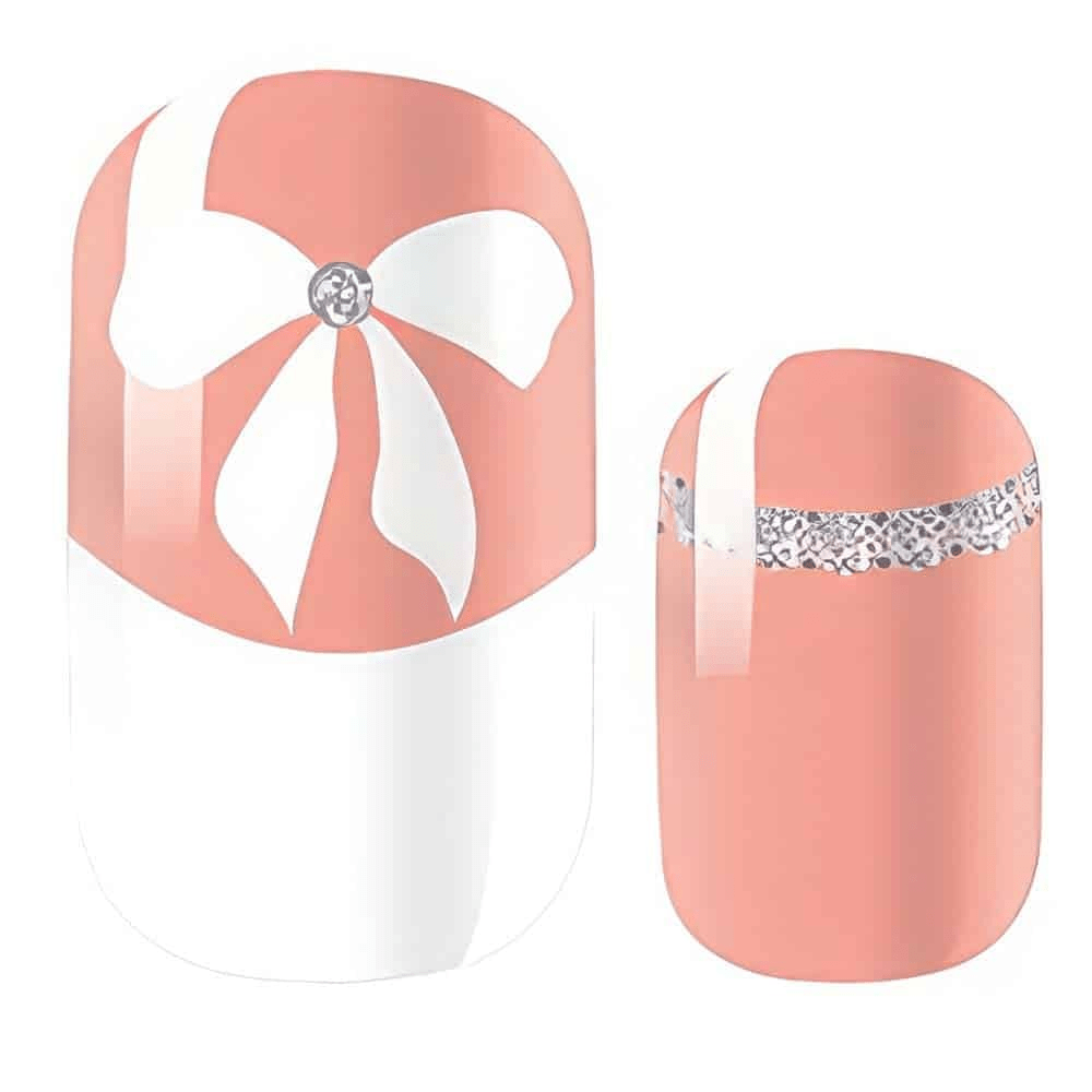 Pink nail wraps with white bow patterns and silver rhinestone accents for manicure
