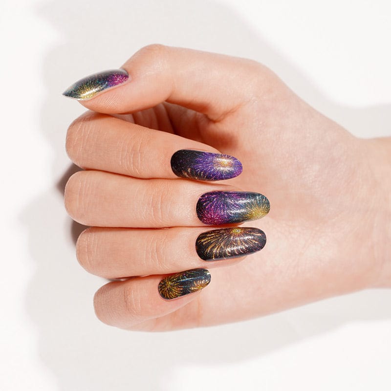Black nail wraps with purple, gold and teal firework burst design