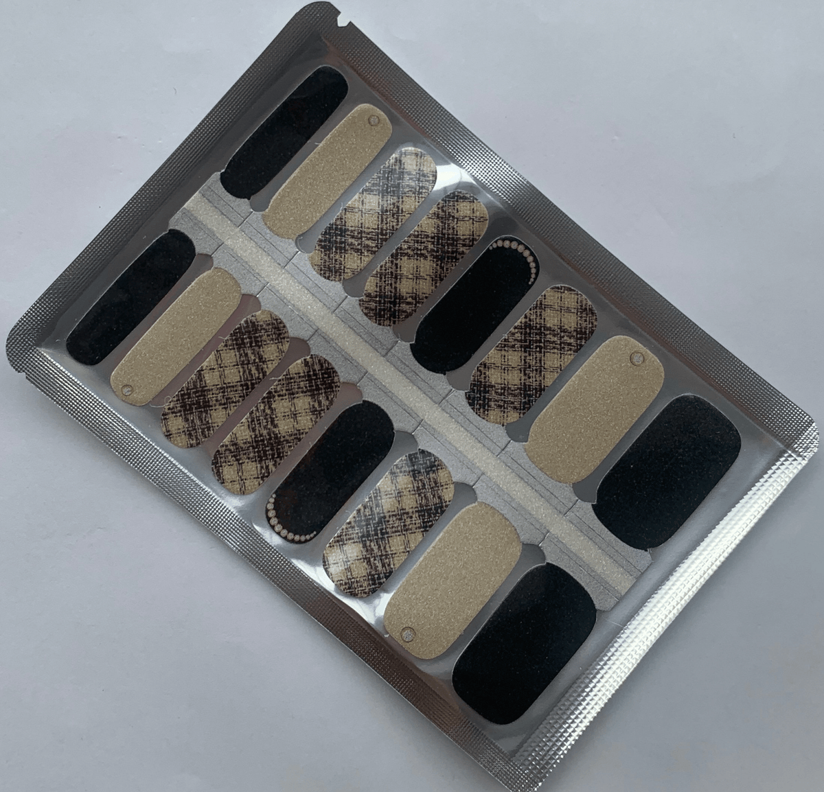 Beige tweed pattern nail wraps with black accents and glitter finish for classic manicure