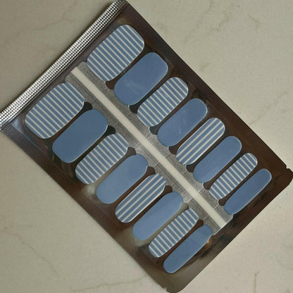 Blue and white striped nail wraps in packaging showing Breton pattern design