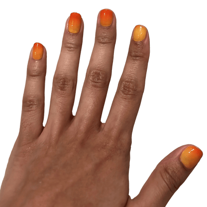 Colour changing nail wraps on hand displaying orange to red gradient effect