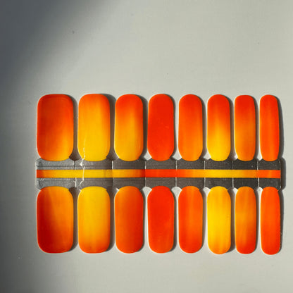 Colour-changing nail wraps in orange red gradient showing temperature reactive finish