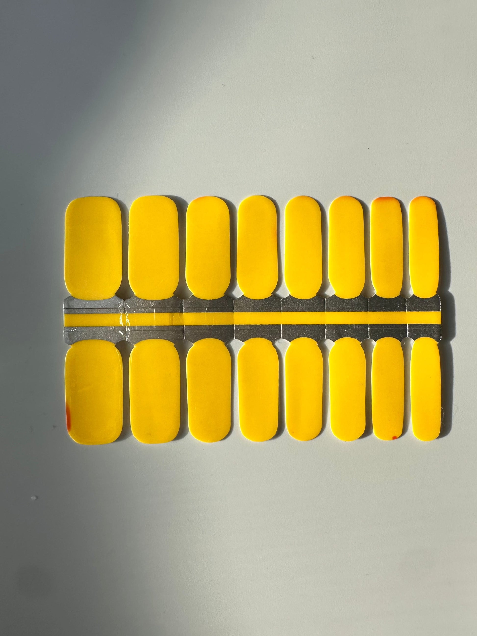 Bright yellow nail wraps showing warm temperature state of colour-changing design