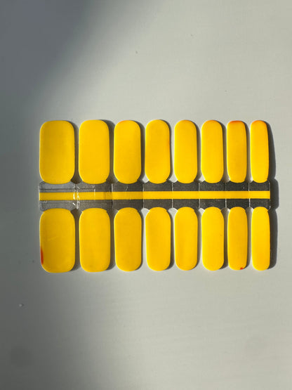 Bright yellow nail wraps showing warm temperature state of colour-changing design