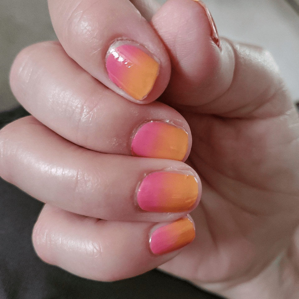 Glossy pink-to-orange sunset ombré nail wraps on short natural nails