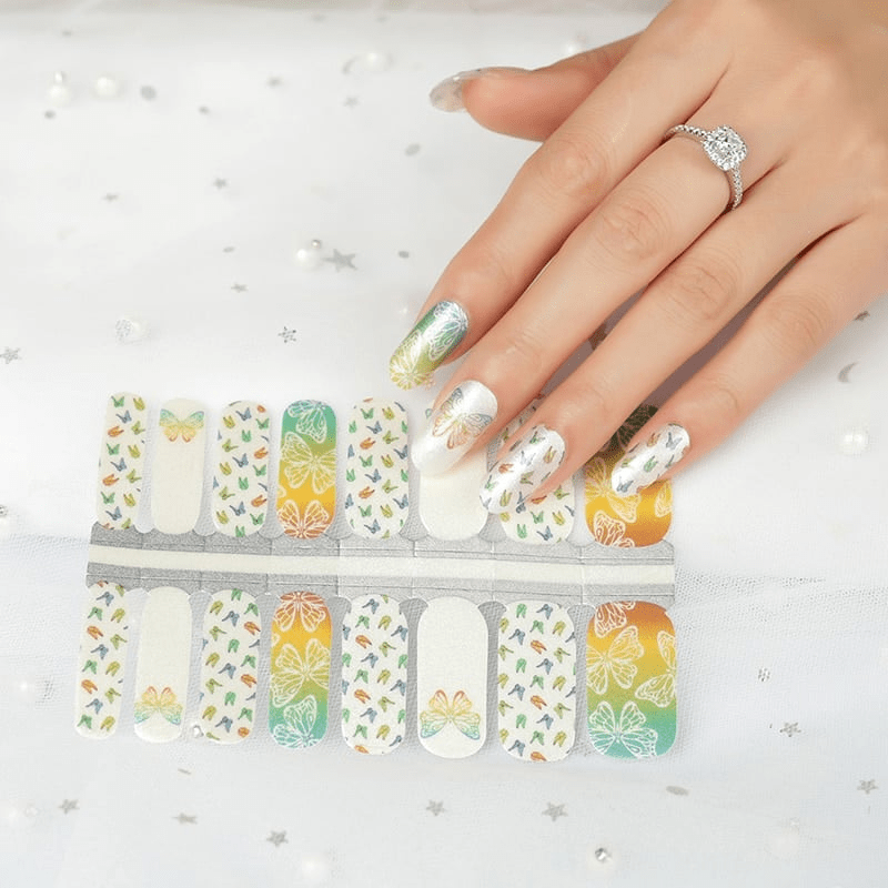 Holy Classics nail wraps in white and orange-green ombre with butterfly and bird outline motifs
