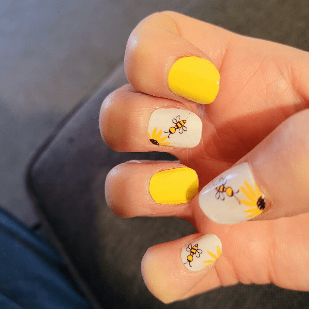 Yellow and white nail wraps with cute bee design on hand nail art