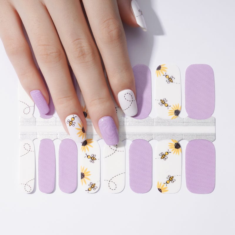 Purple and white bee-themed nail wraps showing manicure design with honeybee pattern