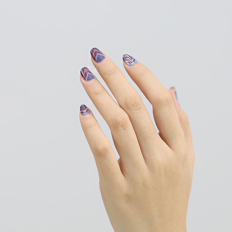 Hand displaying purple blue chevron pattern non-UV nail wraps for at-home manicure