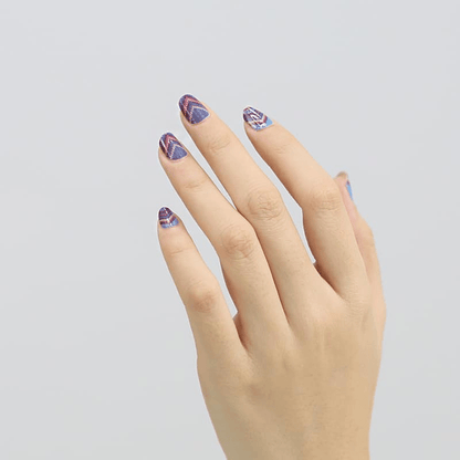 Hand displaying purple blue chevron pattern non-UV nail wraps for at-home manicure