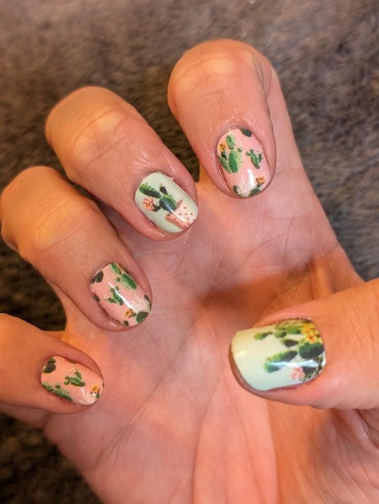 Green cactus pattern nail wraps on hand showing botanical nail art design