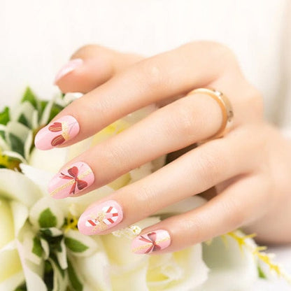 Christmas nail wraps featuring pink candy cane patterns displayed on manicured hand with flowers