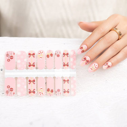 Christmas nail wraps sheet with pink candy cane and bow designs shown with hand