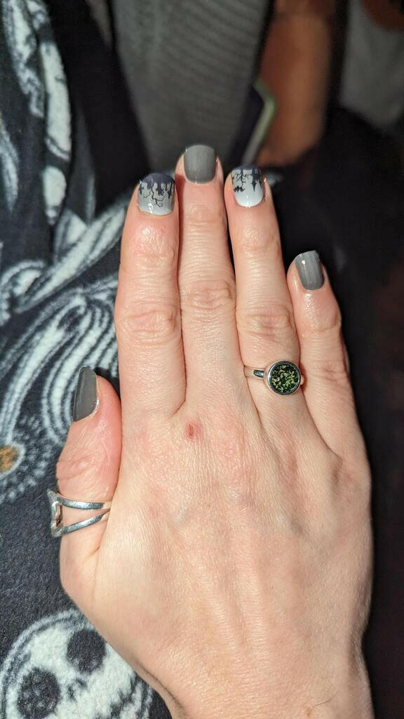 Gothic cemetery nail art design in black and grey tones on hand