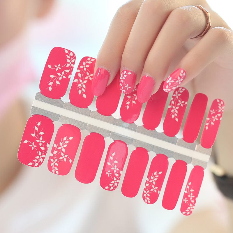 Cerise pink nail wraps with glossy finish and white floral vine accent design