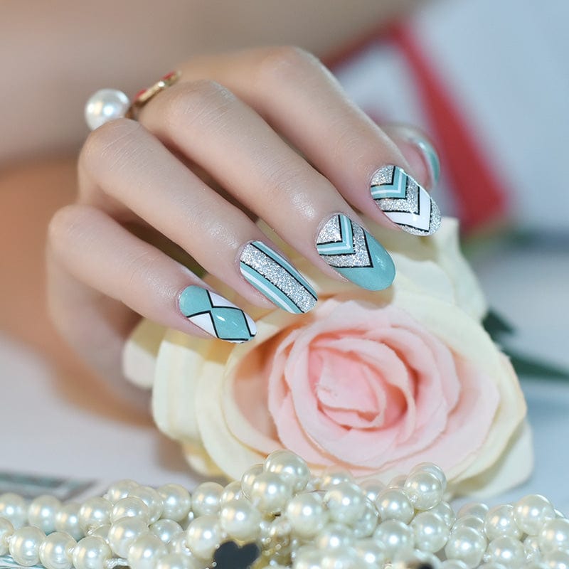 Hand wearing mint green chevron nail art wraps with geometric patterns for at-home manicure