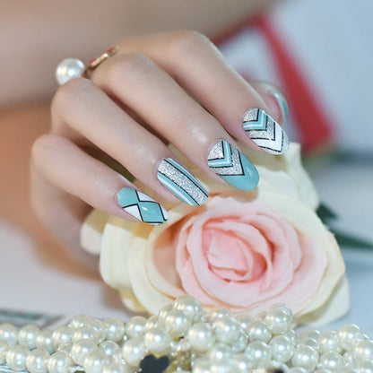 Hand wearing mint green chevron nail art wraps with geometric patterns for at-home manicure