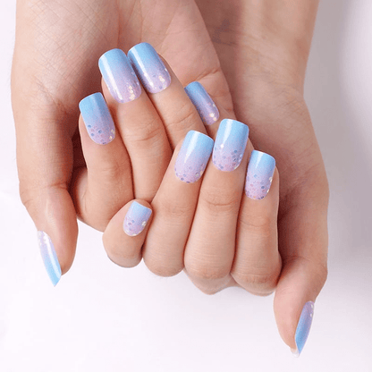 Hand showing blue to pink gradient nail wraps with sparkly confetti design