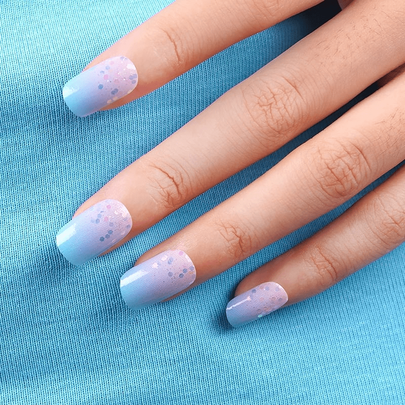 Pastel blue pink ombre nail wraps with glitter confetti pattern on hand