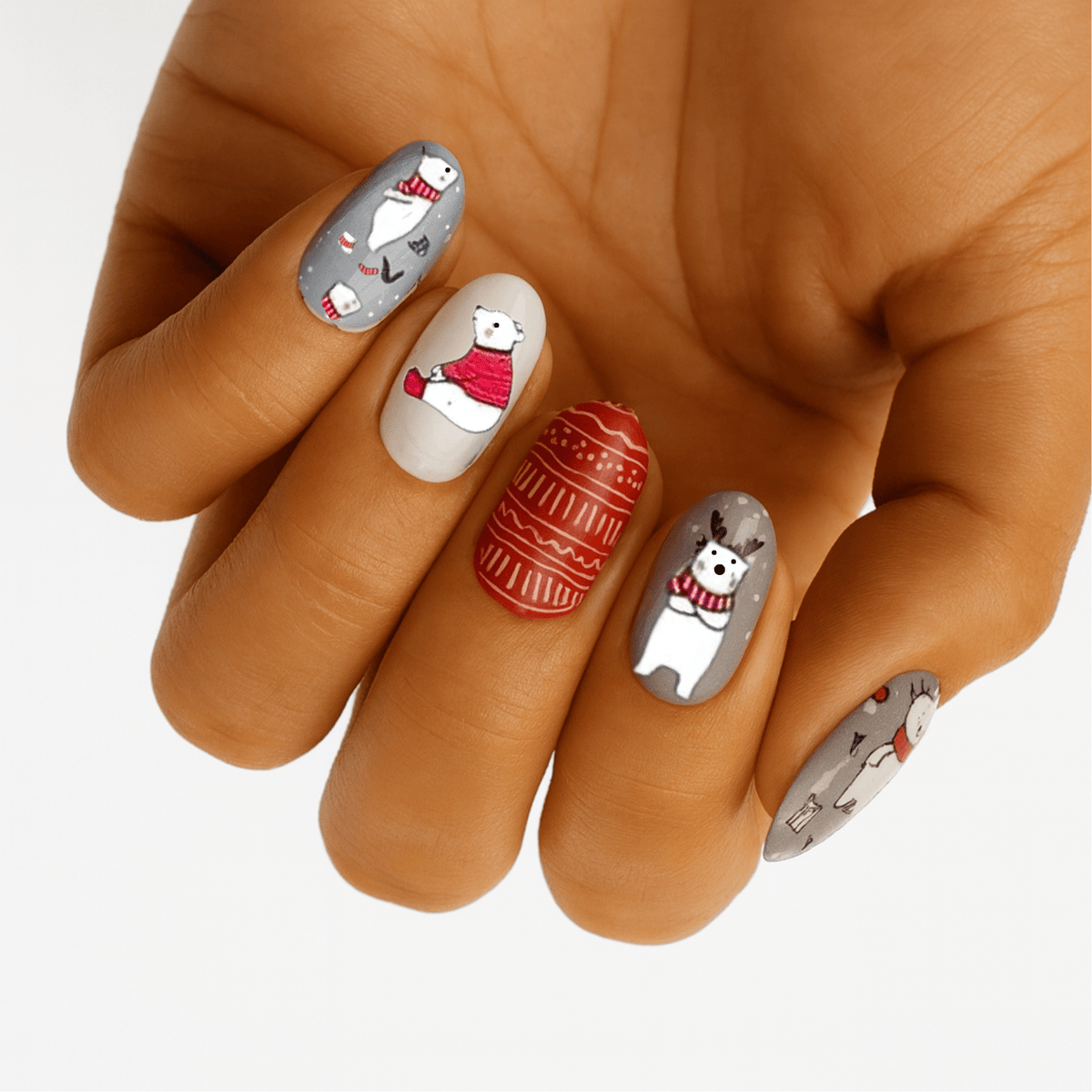 Christmas polar bear nail wraps on hand with red festive designs and white base