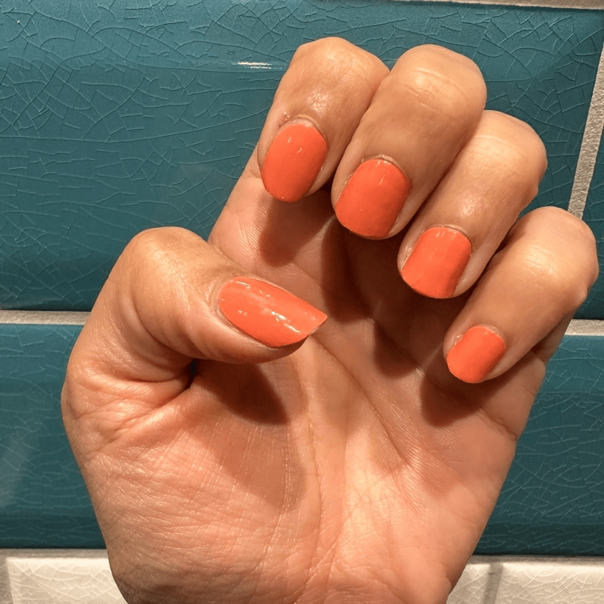 Coral orange glossy non-UV nail wraps on short natural-shaped nails