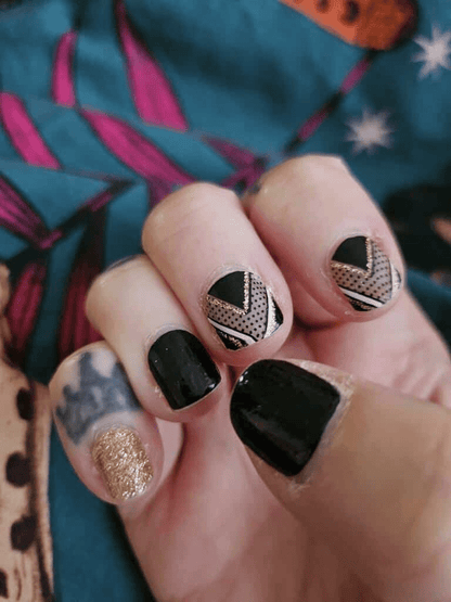 Black nail wraps with gold chevron, polka-dot sheer accents and crown motif