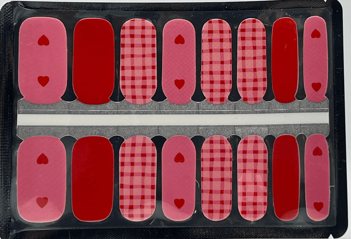 Red and pink gingham check pattern nail wraps with heart accents for Valentine's manicure