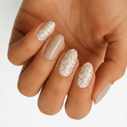 Nude nail wraps with glossy white lace floral pattern on accent nails, almond shape