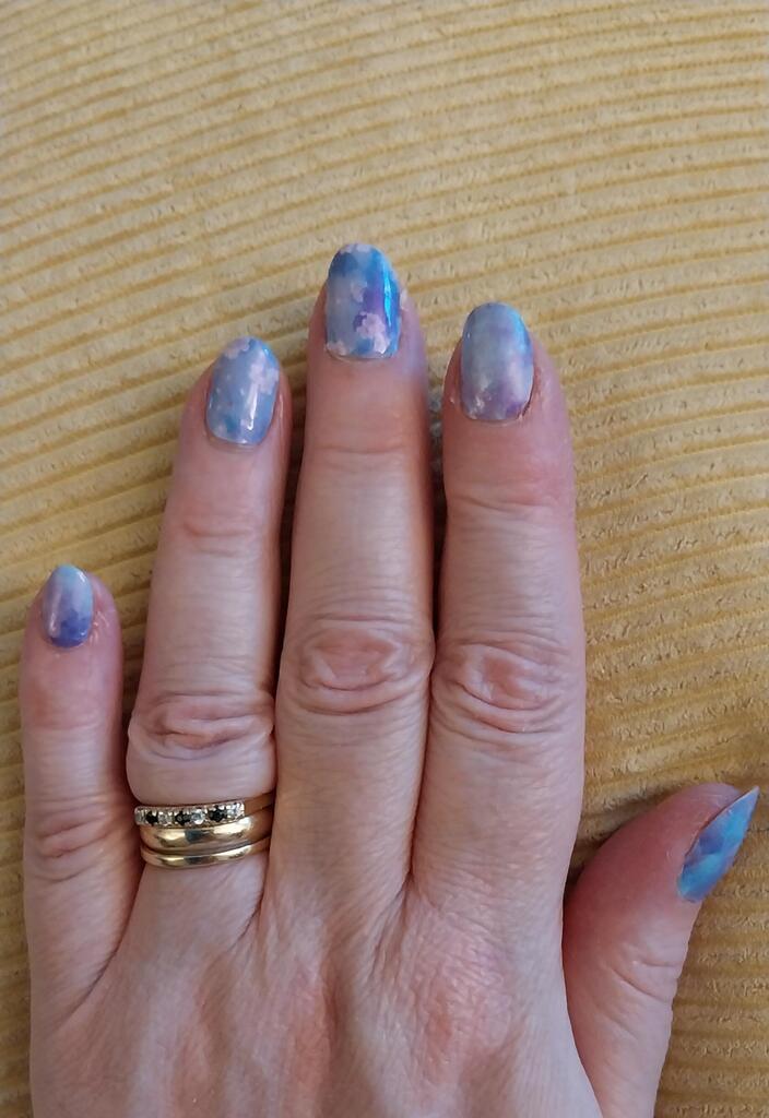 Blue iridescent non-UV nail wraps with holographic finish applied on hand showing at-home manicure