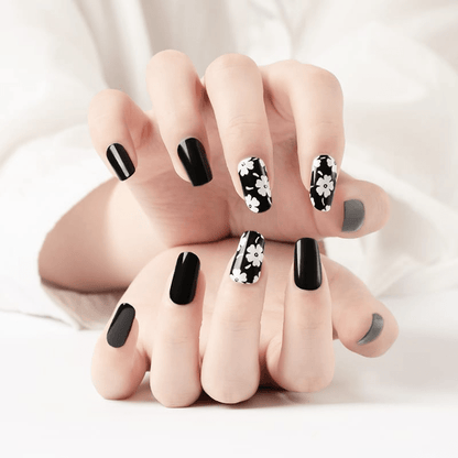 Black and white daisy nail wraps on hands showing gothic floral nail art design