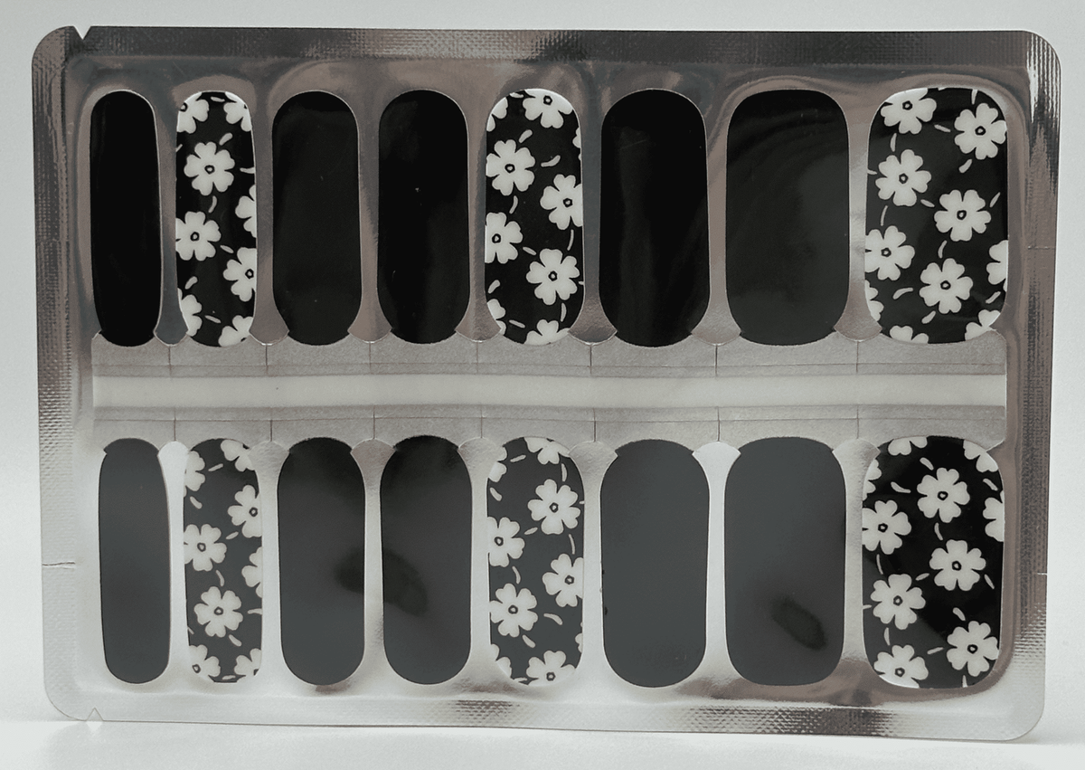 Non-UV nail wrap sheets featuring black base with white daisy floral pattern design