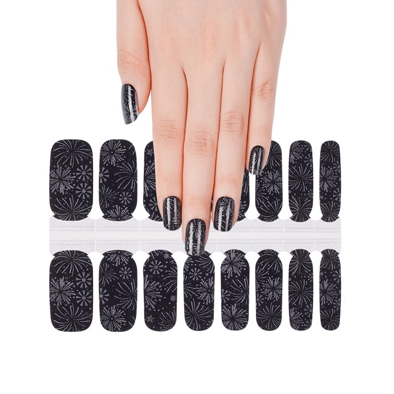Hand wearing black dandelion pattern nail wraps with intricate floral design at-home manicure