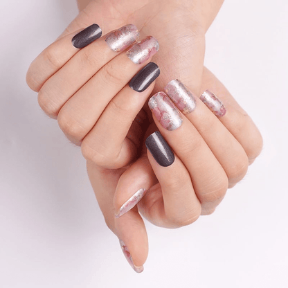 Woman's hands wearing watercolour nail art with coral pink and dark brown nail wraps