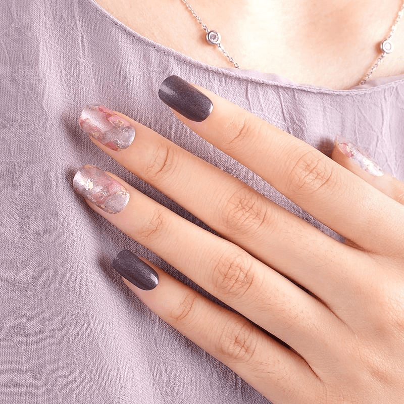 Watercolour marble nail wraps on hand showing pink coral and black matte manicure design