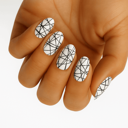 White nail wraps with crisscrossing black line design, oval shape, abstract geometric pattern