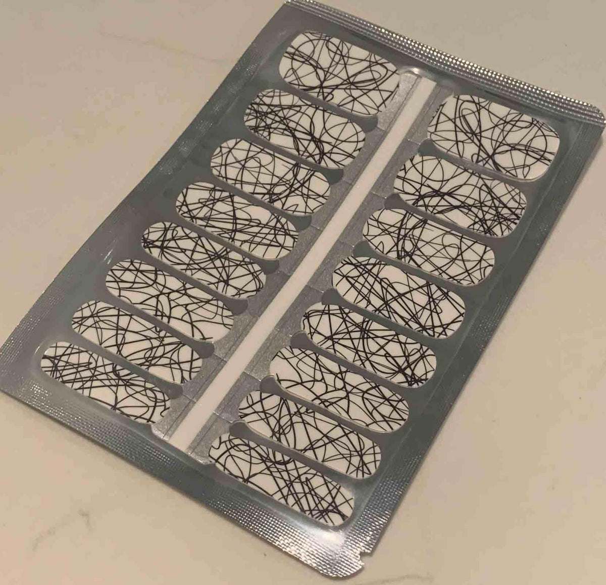 Non-UV nail wraps sheet featuring white base with black geometric line pattern design