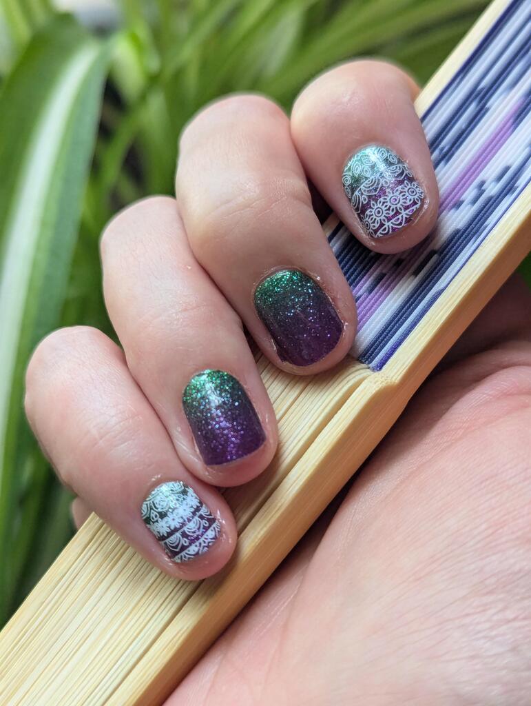 Purple to teal glitter ombre nail wraps on hand displaying shimmery gradient nail art