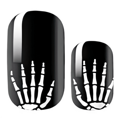Black nail wraps featuring white skeleton bone pattern for spooky Halloween manicure