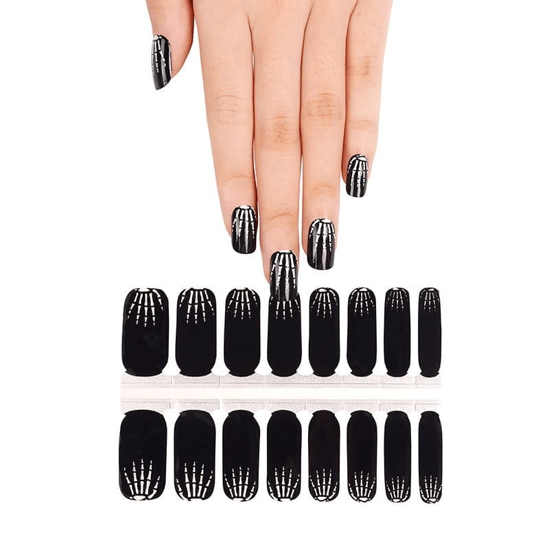 Black X-ray skeleton nail wraps displayed on hand with complete set showing Halloween nail art