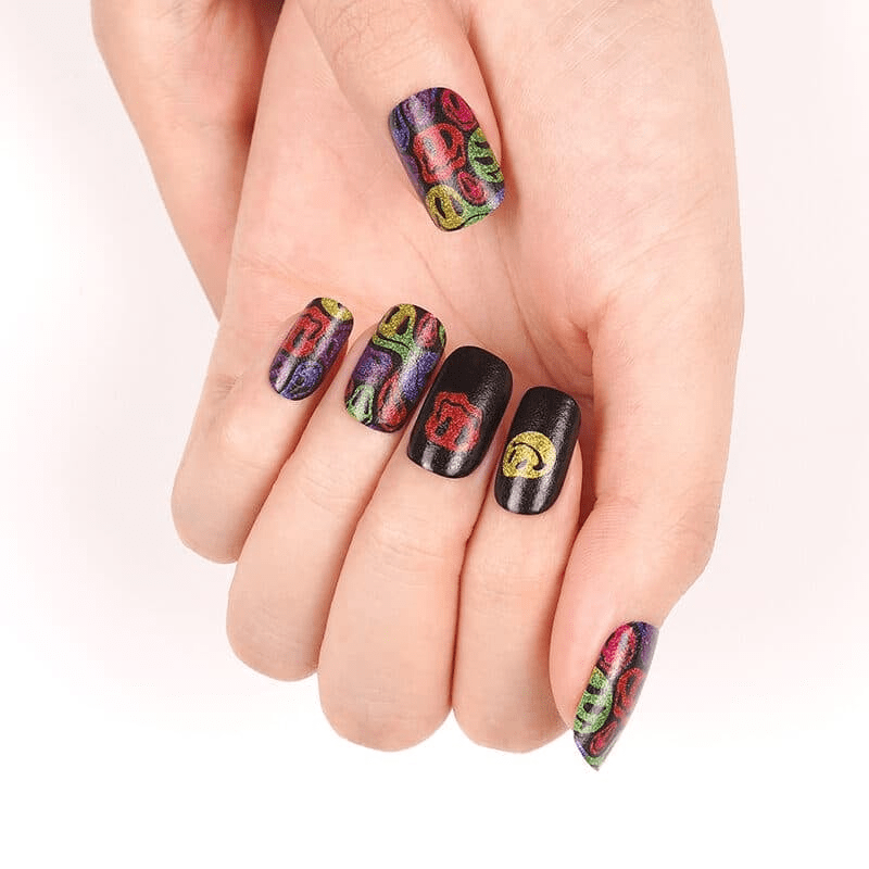 Hand displaying colourful smiley face nail art wraps with bold neon rainbow patterns