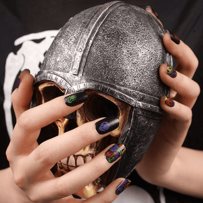 Gothic skull decoration with hands wearing vibrant multicoloured smiley face nail wraps