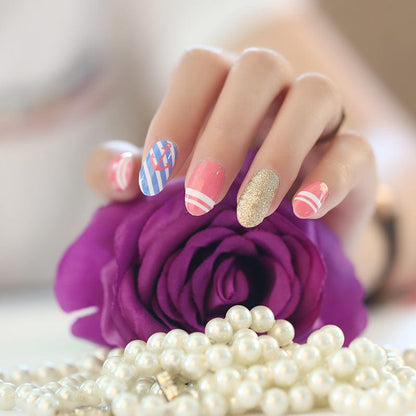 Colourful nail art featuring blue stripes, pink designs and gold glitter on hand with purple rose