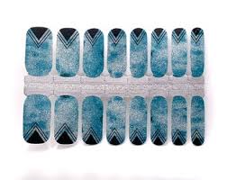 Blue geometric nail wraps with silver metallic triangle patterns and glitter finish