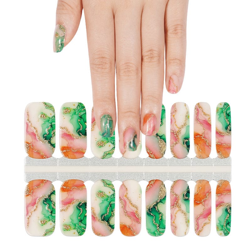 Hand selecting marble nail wraps with green orange gold foil pattern from sheet