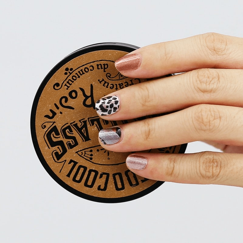 Manicured hand with leopard print nail wraps showing brown caramel animal print finish