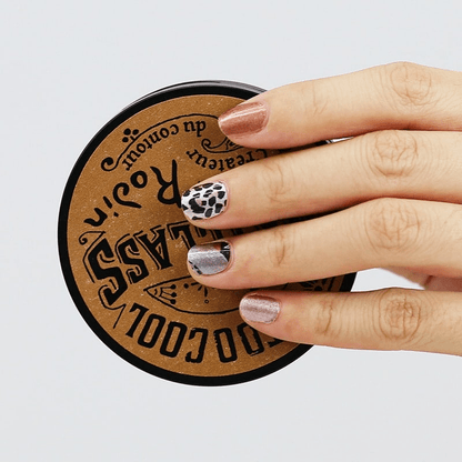 Manicured hand with leopard print nail wraps showing brown caramel animal print finish