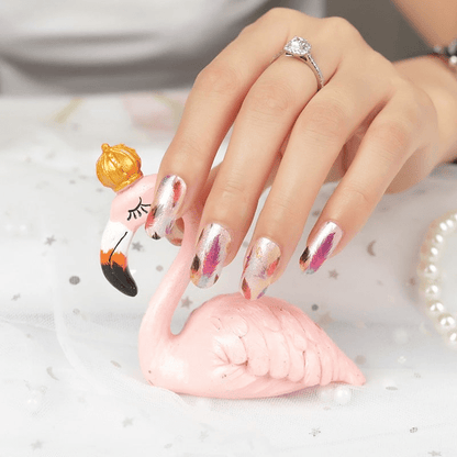 Hand wearing feather design nail wraps with pink flamingo decoration showing autumn nail art
