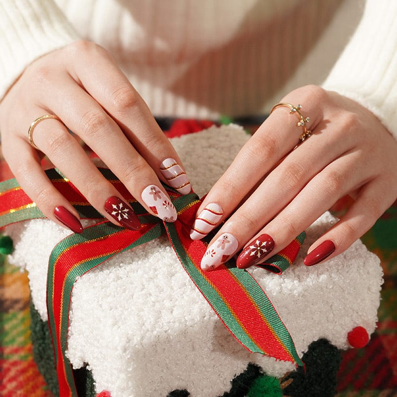 Christmas nail wraps on hands holding white gift with red ribbon bow